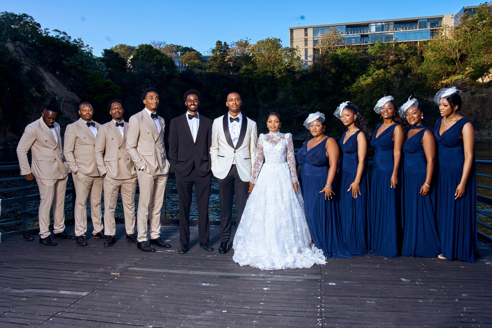 Bride and groom with their wedding party on an outdoor terrace.